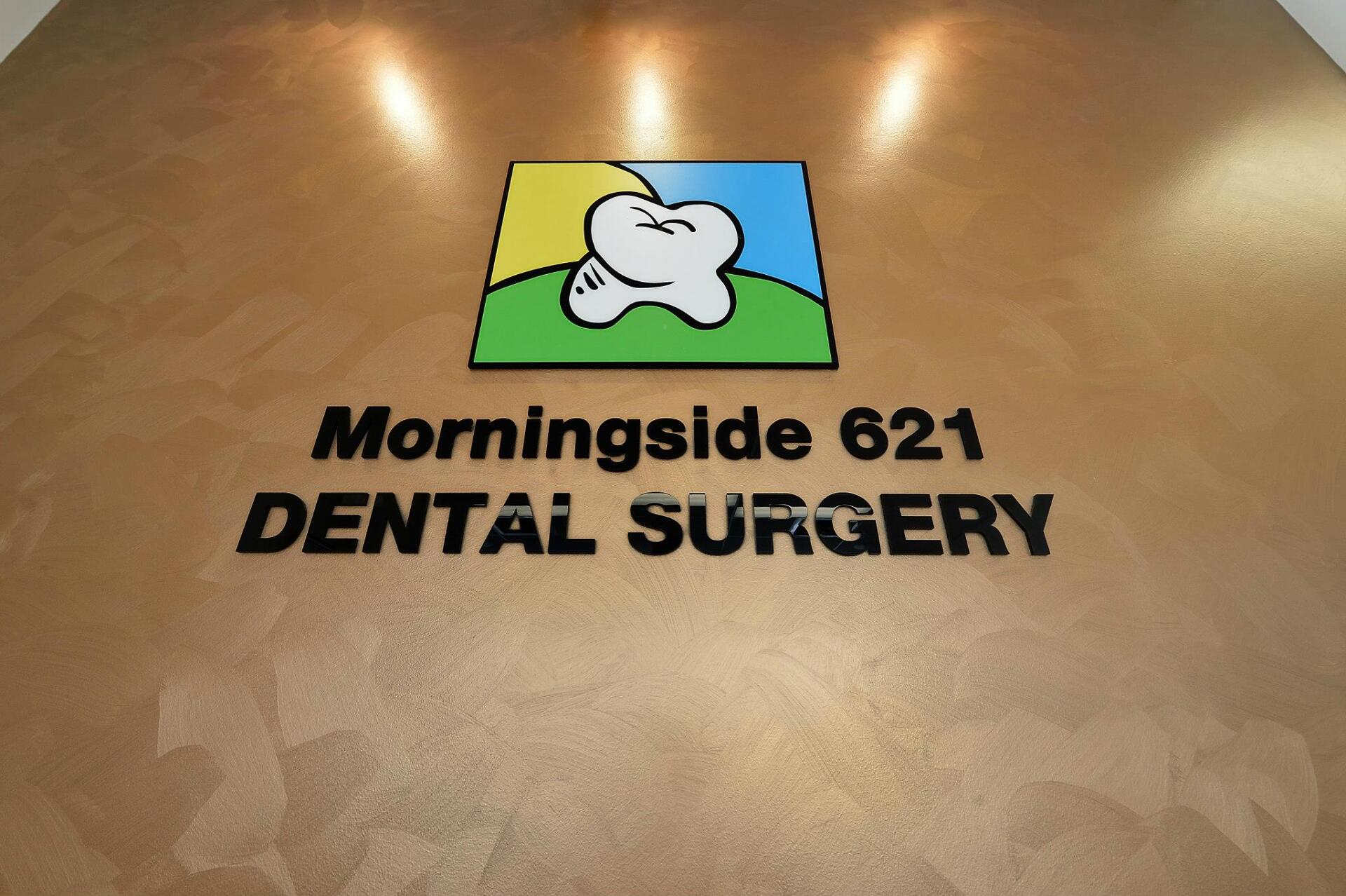 Sign for Morningside 621 Dental Surgery, featuring a tooth icon with a green hill and blue and yellow background.