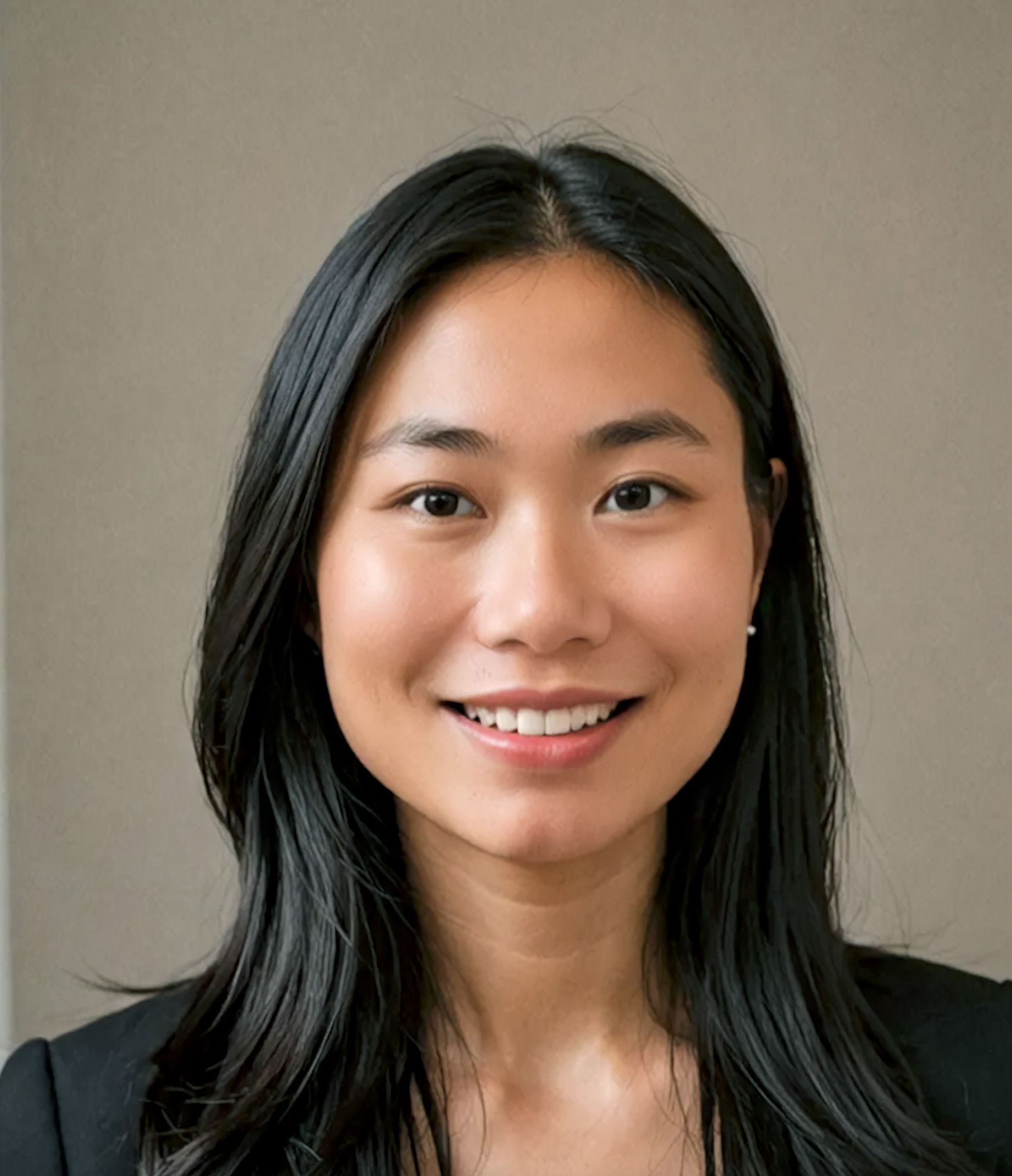 Smiling Asian woman with long black hair in a professional setting, wearing a black blazer.