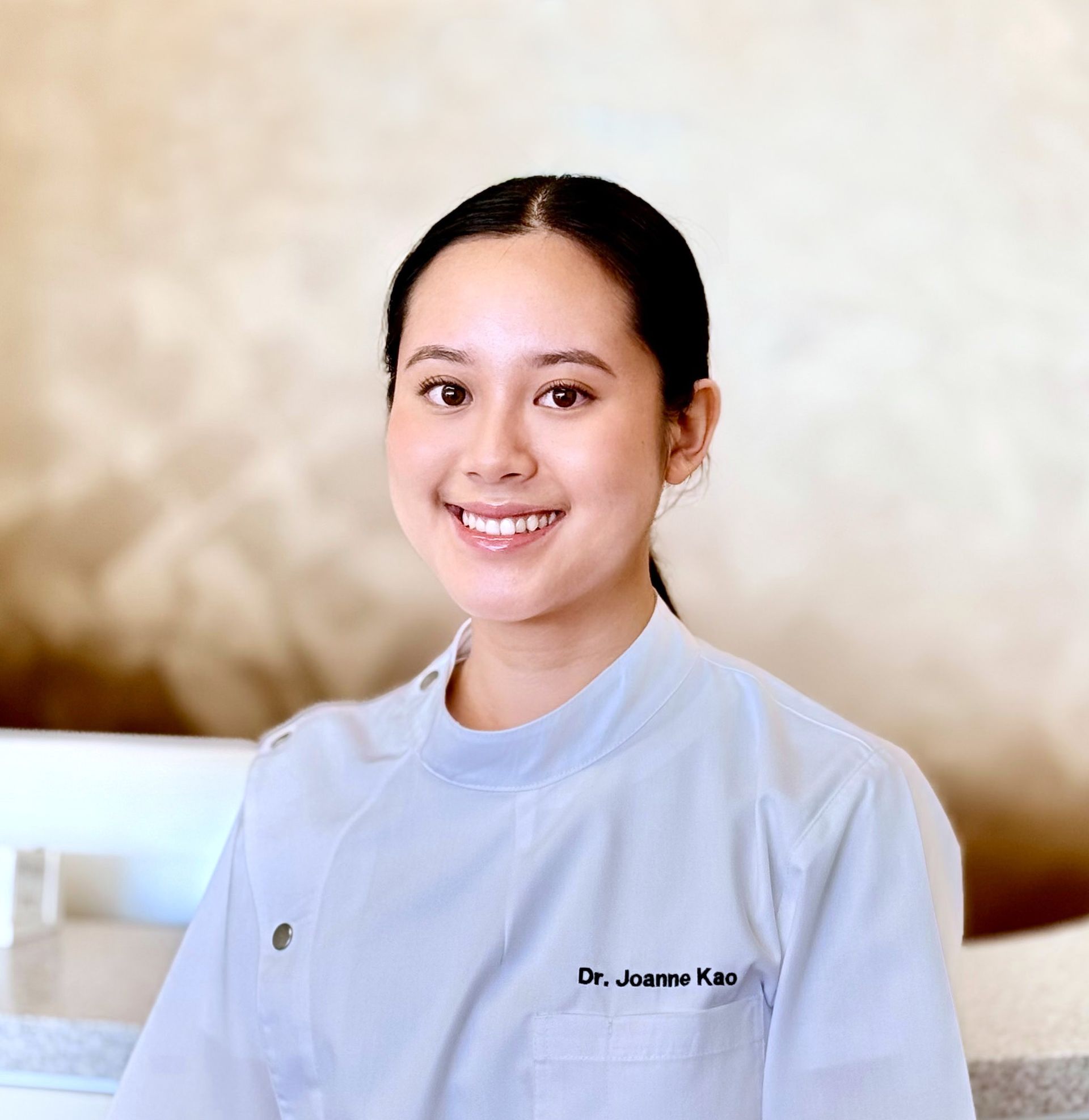 Smiling Asian woman, Dr. Joanne Kao, in a white coat, looking directly at the viewer.
